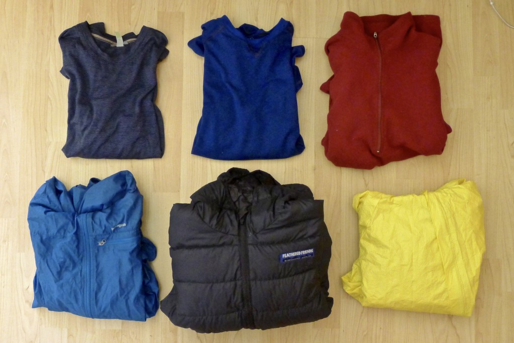 The tops I will bring on our trip to Europe, from top left: SmartWool lightweight long sleeve, Patagonia Capilene 2 long sleeve, REI midweight 1/4 zip fleece, Patagonia Houdini wind shirt, Feathered Friends Daybreak puffy, O2 Rainwear hooded rain jacket.