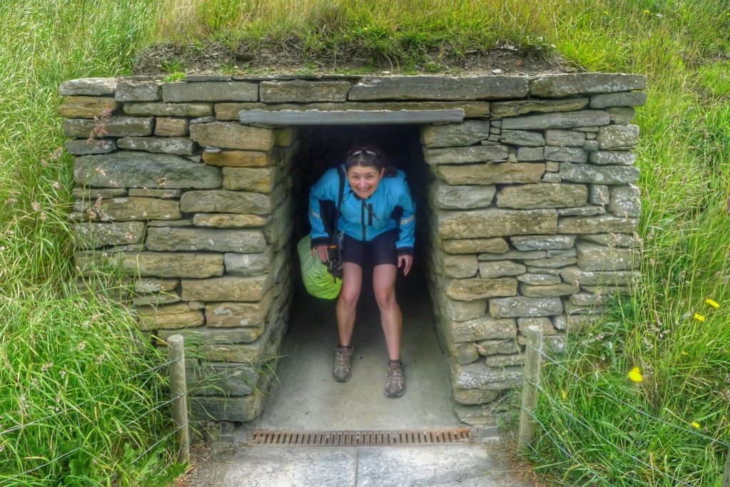 Carrie emerges from a replica building at Skara Brae. 