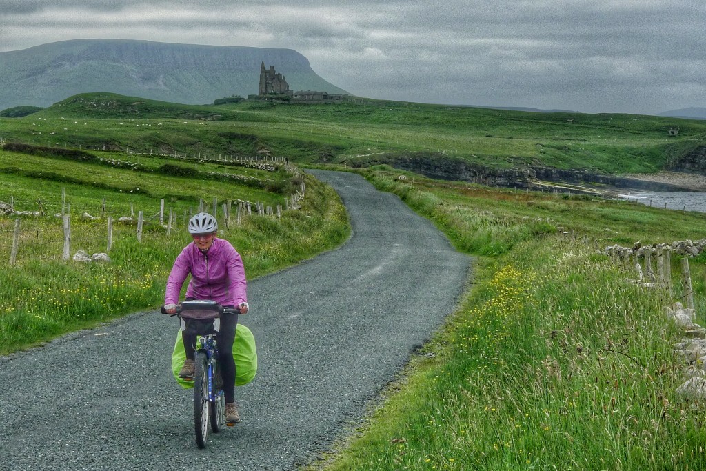 Carrie rides away from a castle and a green mesa. Only in Ireland.